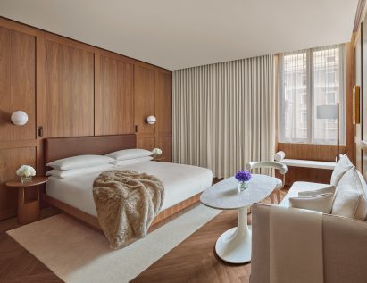 Bright guest room with walnut panelling and beige furniture