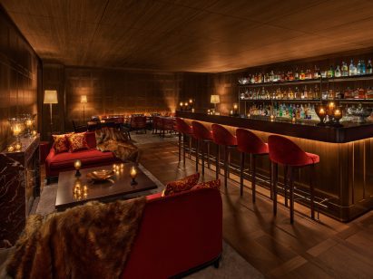 Cosy bar with walnut panelling and dark pink velvet furniture