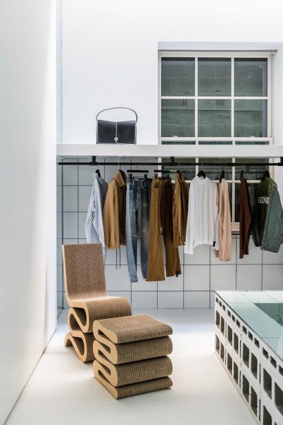 Frank Gehry Wiggle Chair next to clothing displayed on rails