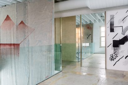 Upper-floor rooms partitioned by artworks and glass balustrades