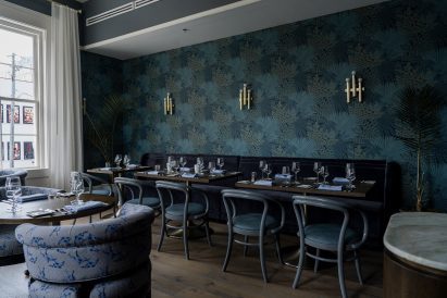 Restaurant with dark blue-green walls and furniture