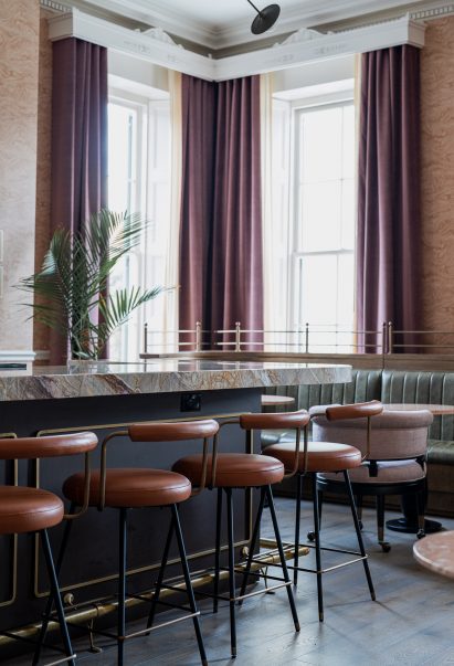 Bar with brown leather stools, stone countertop and purple counter