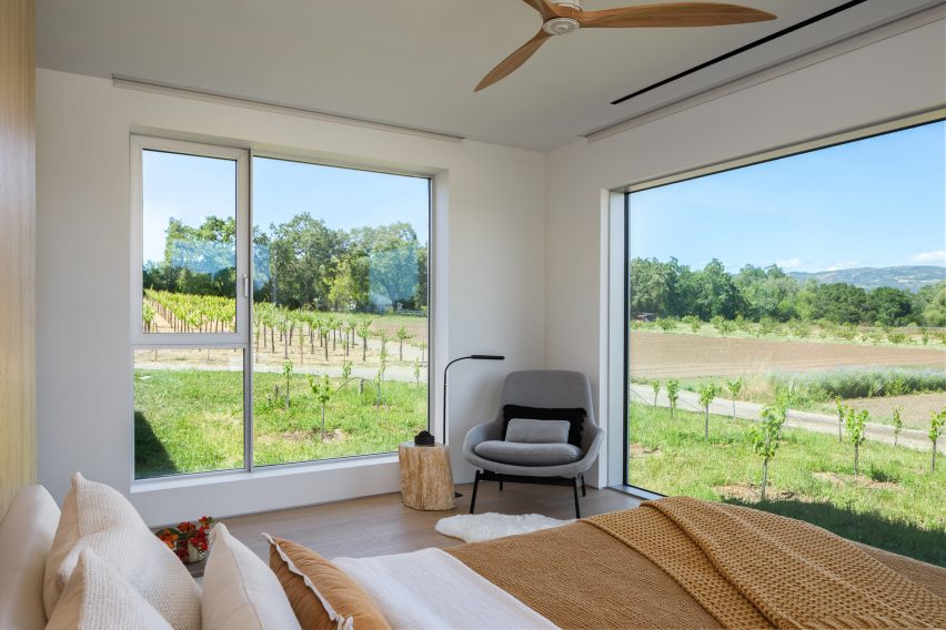 Lounge chair in a bedroom with windows overlooking a field