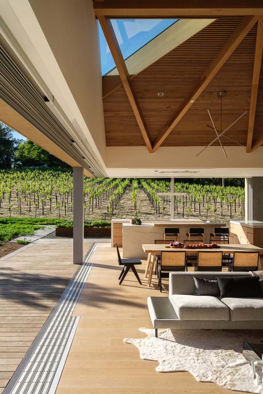 Open-plan living and dining room in a timber farmhouse with open walls