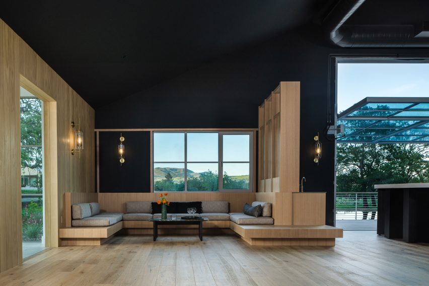 Black open-plan space in a timber barn with large window openings