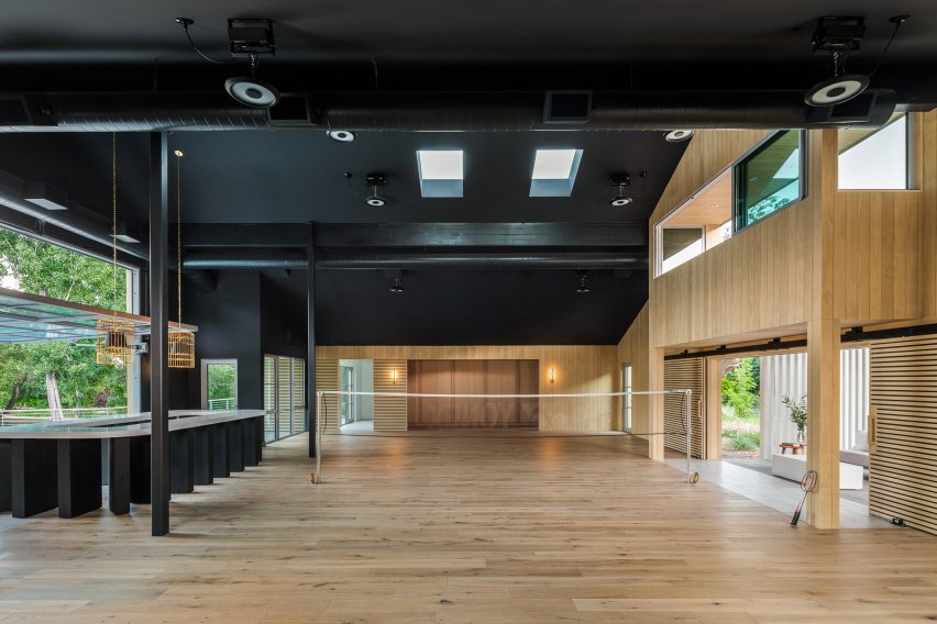 Black open-plan space in a timber barn with large window openings