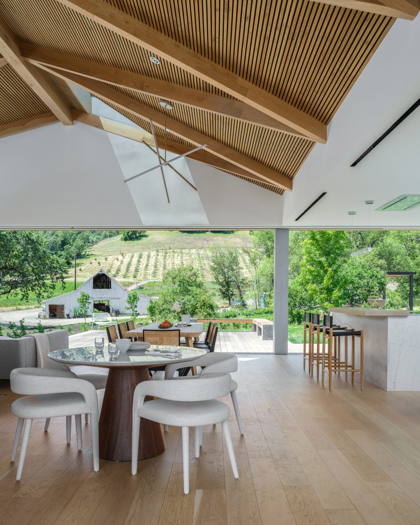 Open-plan living and dining room in a timber barn house in California