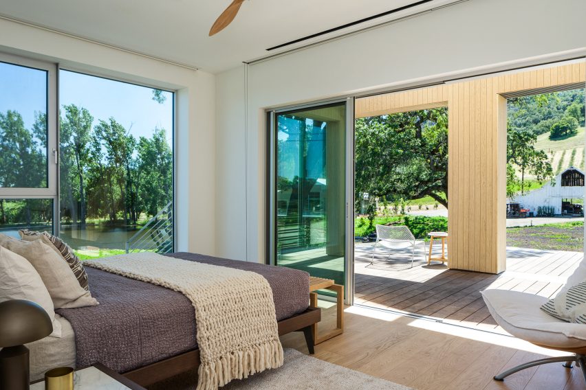 Bedroom in a timber barn house that opens onto the garden