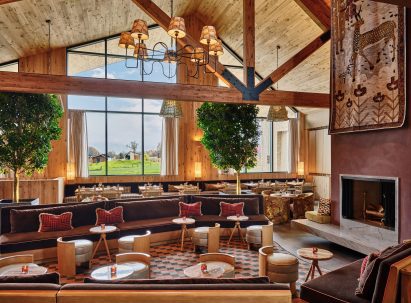 Restaurant dining room with high ceiling, exposed beams and warm colour palette