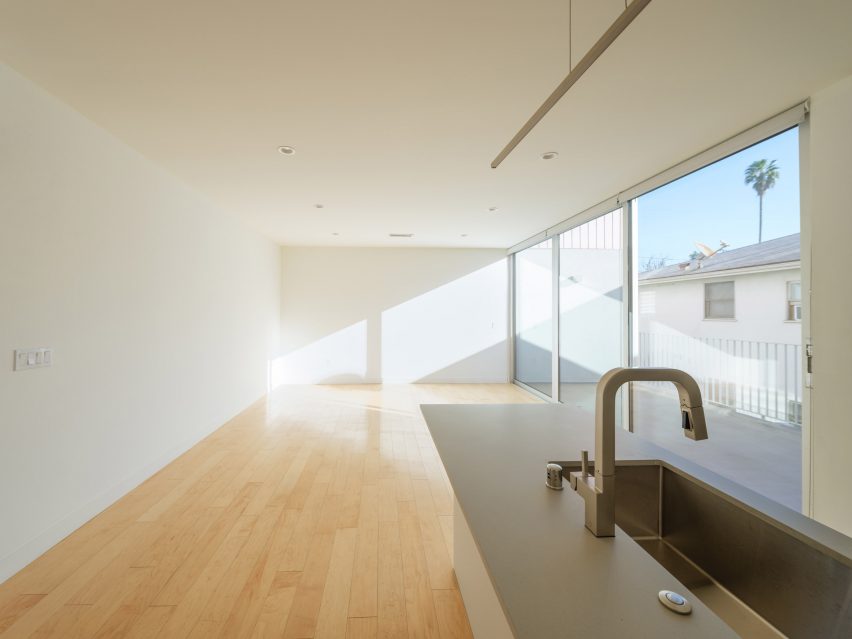 Interior space with white walls, timber floors and grey kitchen worktop