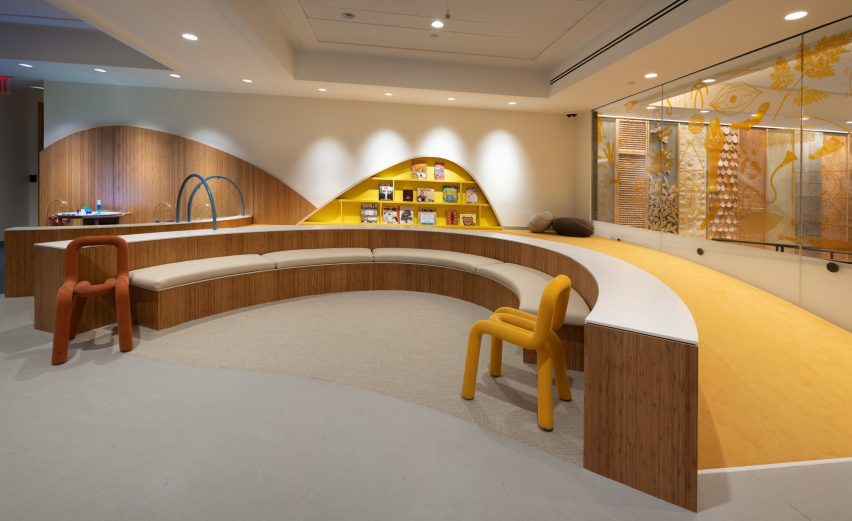 A room with curving benches and a yellow wall