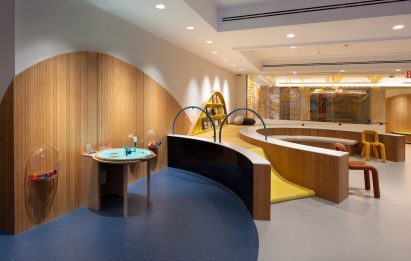 A children's playroom with wooden benches and a ramp