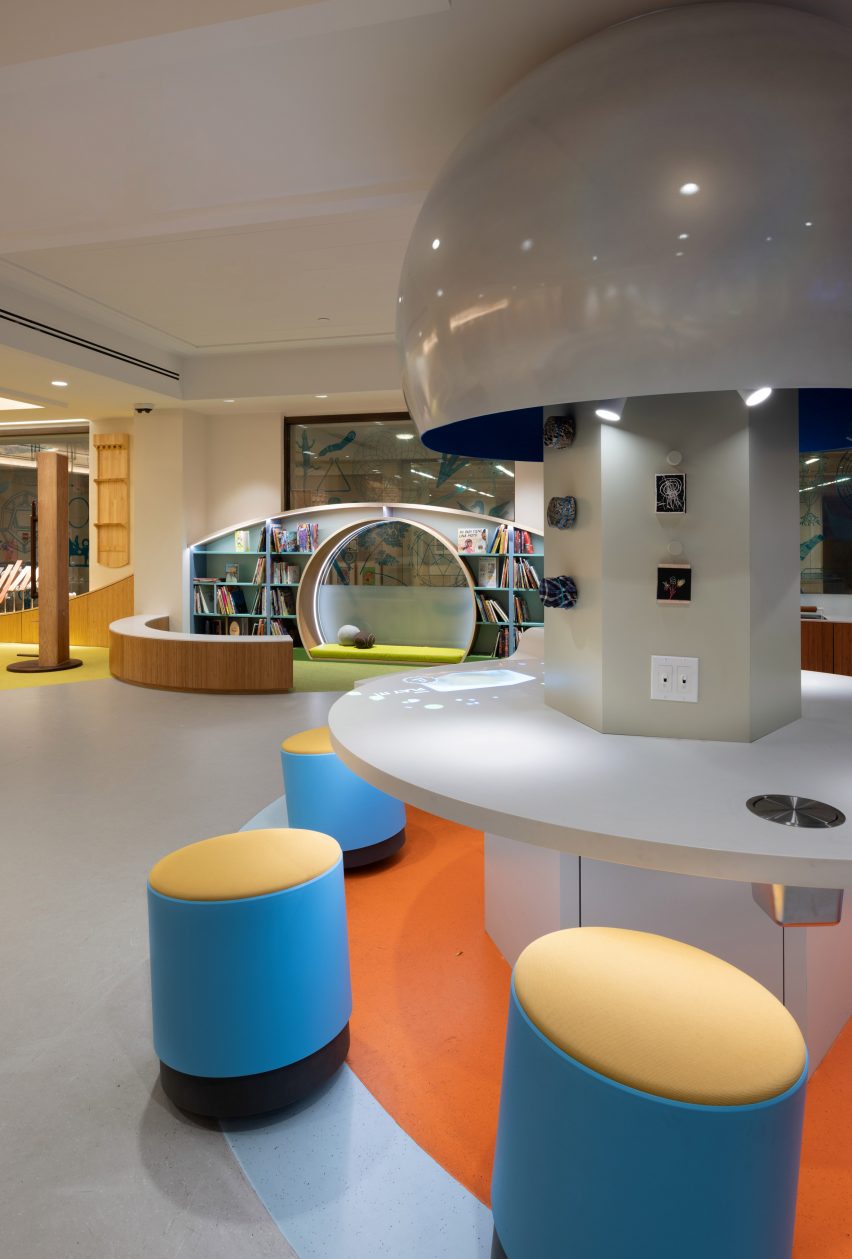 Playroom with blue stools and a curving bookcase