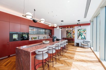 Kitchen with red cupboards and wooden flooring 