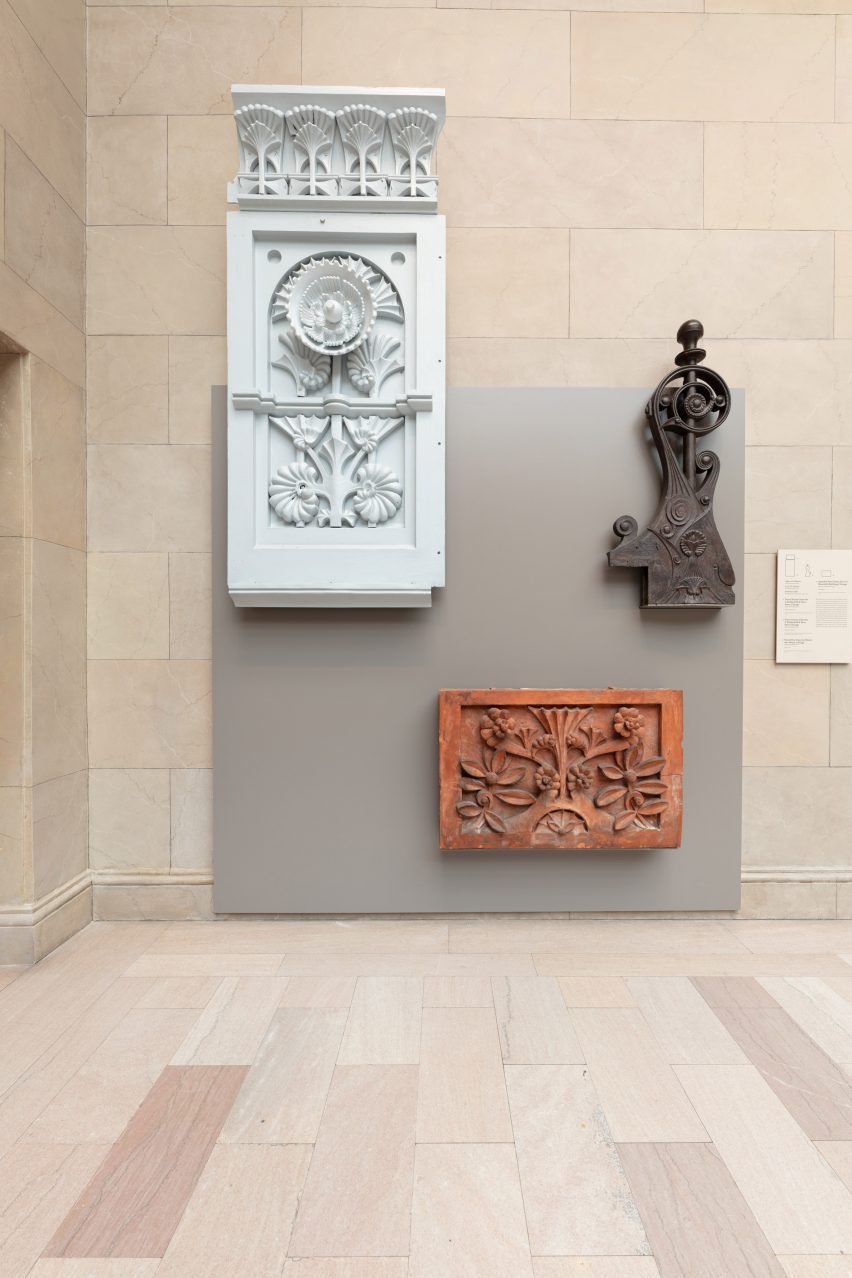 Cornices and other pieces of buildings attached to wall on a gray panel