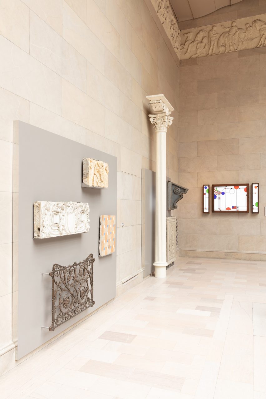 A column, gate, and fragments of buildings attached to a wall