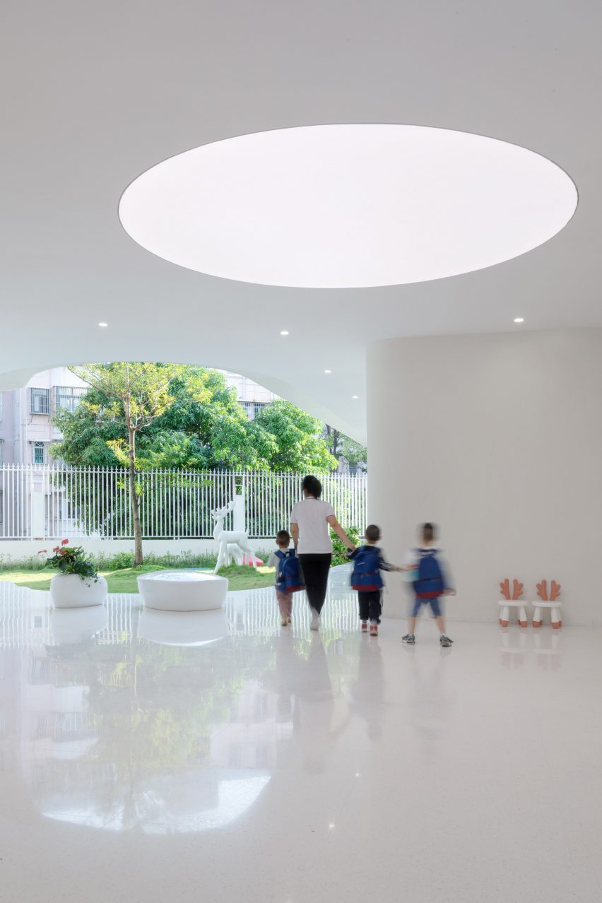 White semi-open outdoor space at the Kindergarten of Museum Forest by Atelier Apeiron