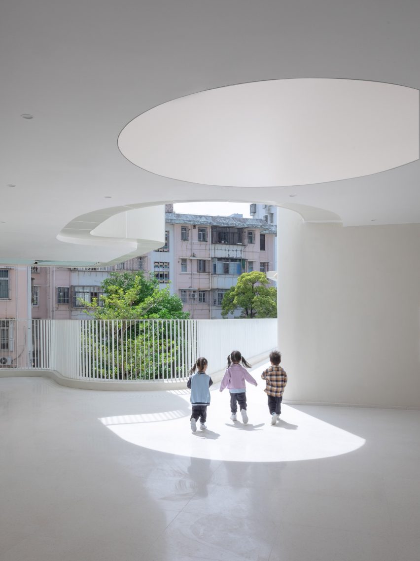 White terrace space with a circular light at the Kindergarten of Museum Forest by Atelier Apeiron