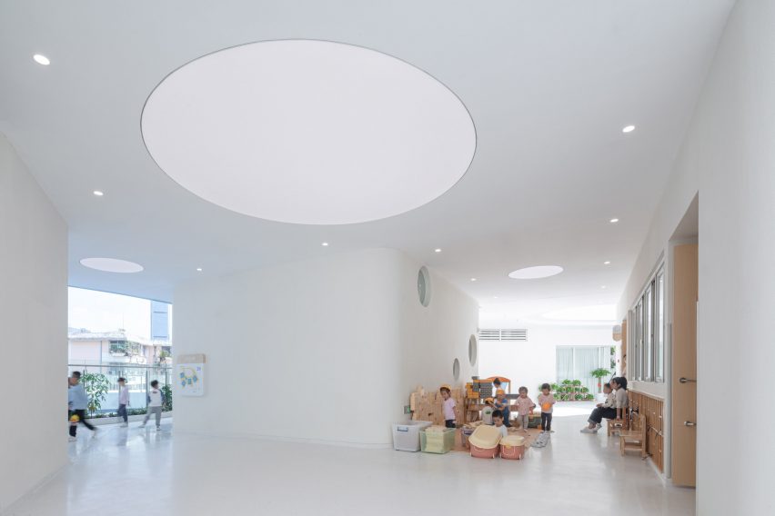 White internal space with a circular light at the Kindergarten of Museum Forest by Atelier Apeiron
