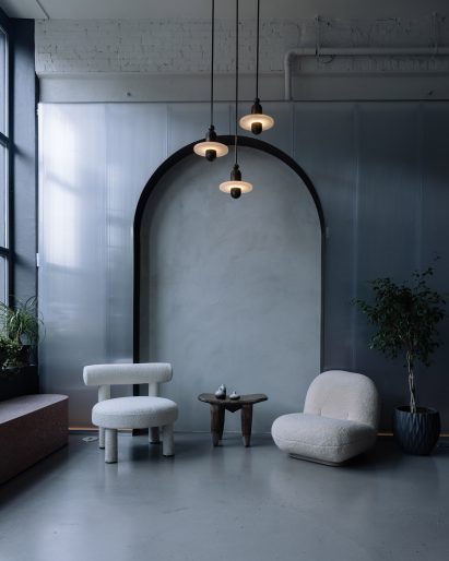 Boucle seats and Apparatus lights in front of an arched niche