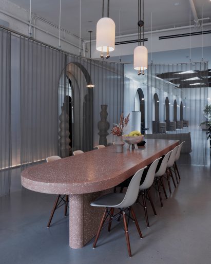 A pink-concrete table shrouded by a sheer curtain