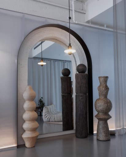Arched niche with a mirrored back and totem-like sculptures