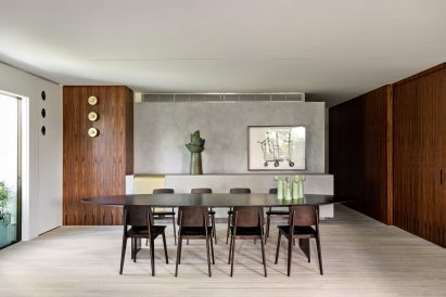 Dining room with oval table, Jean Prouvé chairs and dark wood panelling