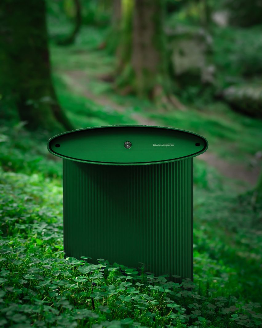 Close-up photo of the side profile of the Bello! aluminium outdoor bench by Hydro in a green colour, sat within a dense bright green forest