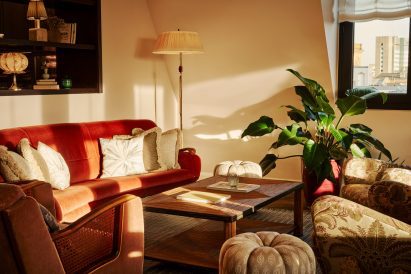 Close-up of seating area with burnt orange velvet sofa