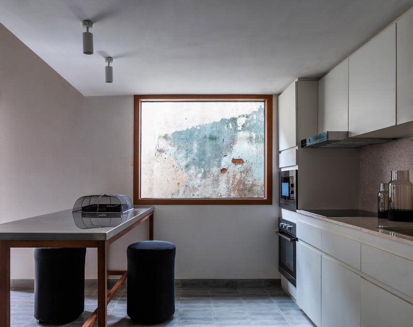 White kitchen with white units and a wooden table