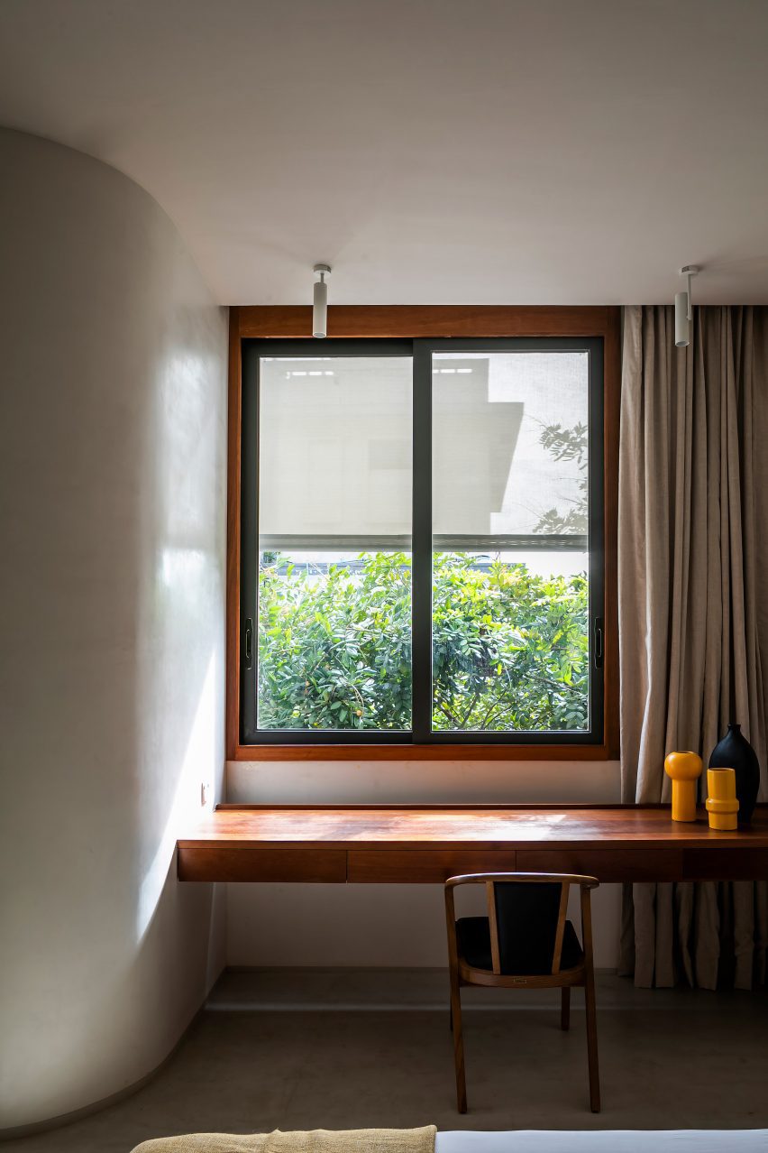 Wood desk below a window in a white room