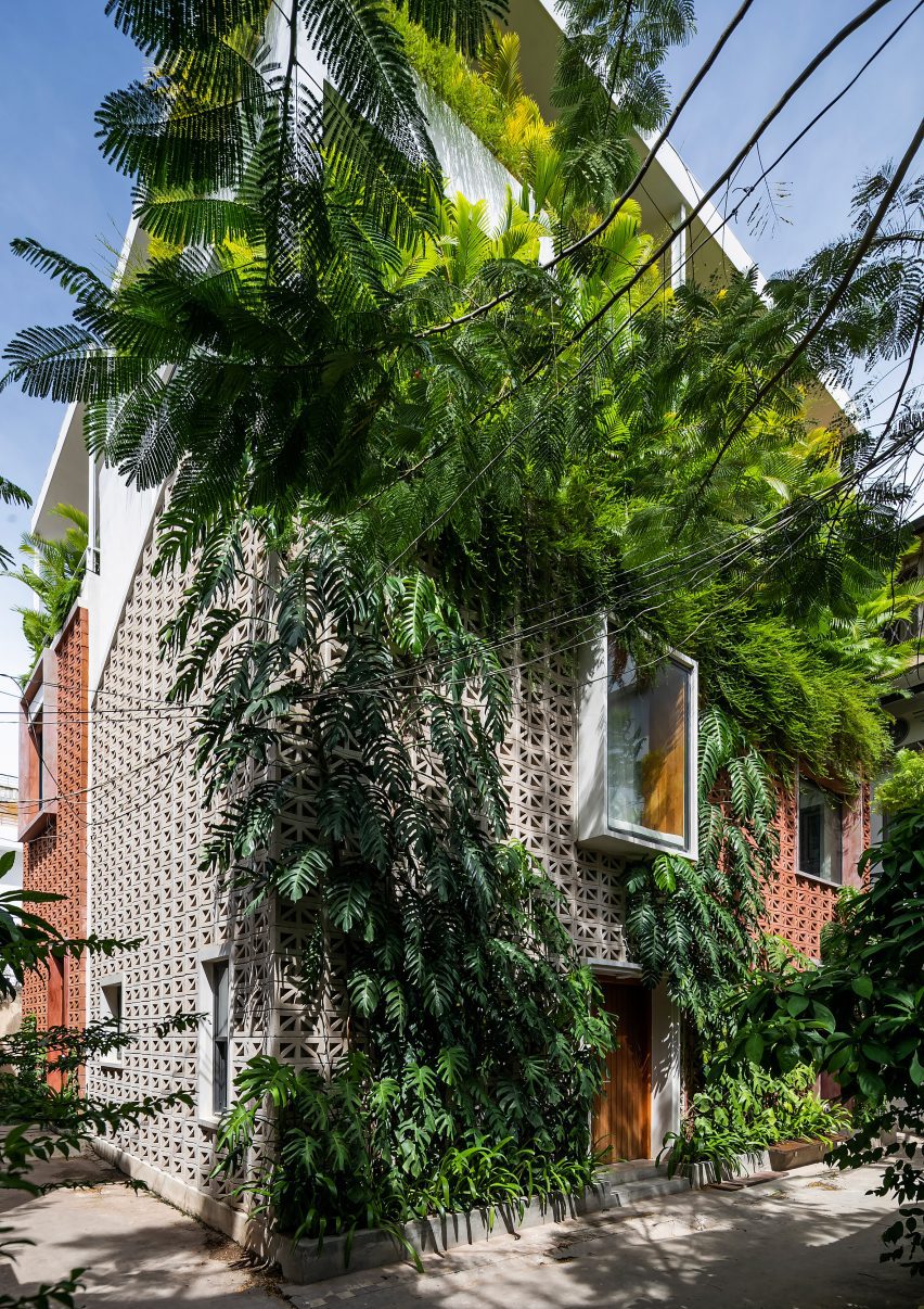 Perforated cement block building in Cambodia covered in plants