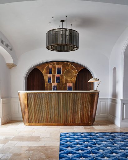 Metal reception counter with tiled backdrop within a white room