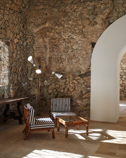 Old stone room furnished with chairs and a lamp