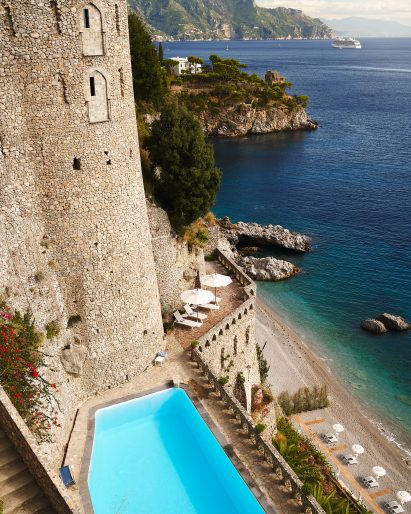 Swimming pool integrated into old stone ramparts with sea view beyond