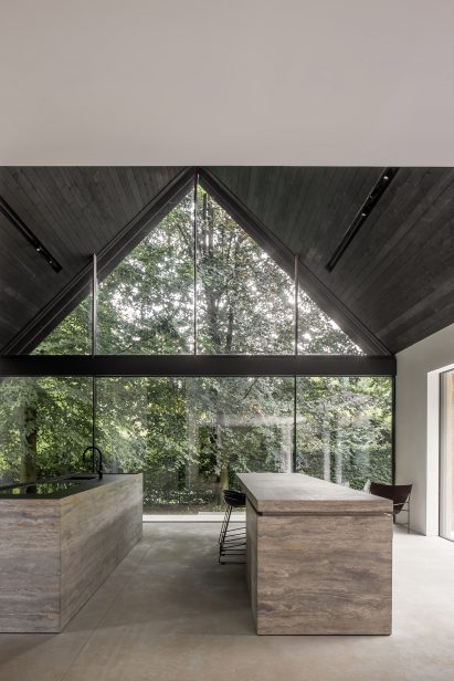 Kitchen with stone islands in a pitched roof interior with a glazed gable end
