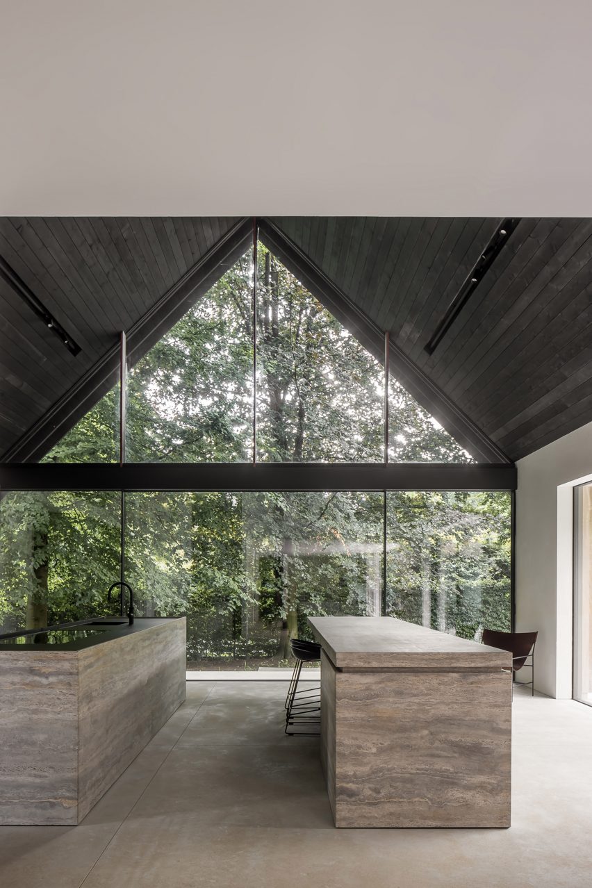 Kitchen with stone islands in a pitched roof interior with a glazed gable end