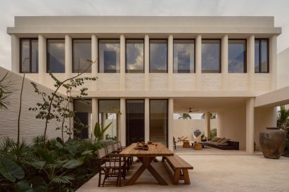 Courtyard with large wooden dining table and tropical planting
