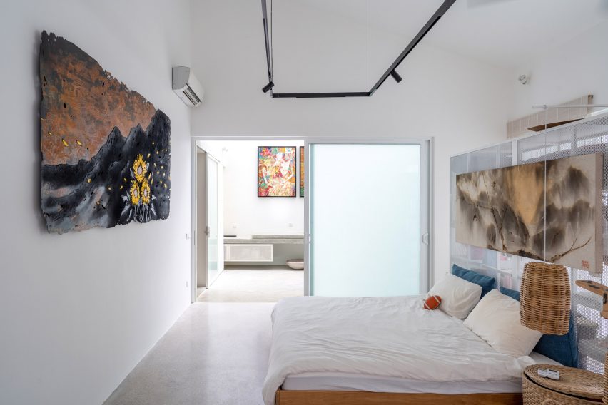 Bedroom with white walls, concrete flooring and sliding glass doors leading outside
