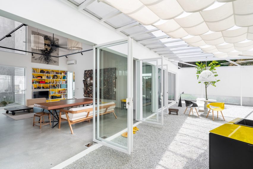 Outdoor courtyard at the Introverse house with folding glass doors leading to the living room