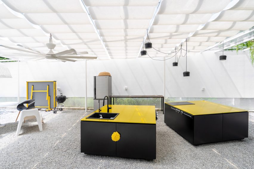 Outdoor courtyard at the Introverse house with black and yellow outdoor kitchen islands