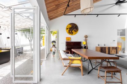 White living room with glass doors opening onto a courtyard by Core Design Workshop