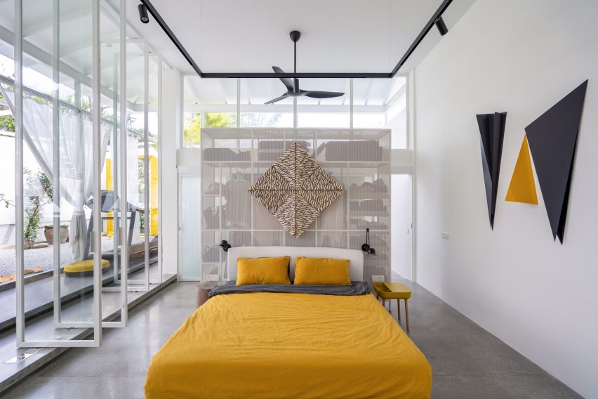 Double-height bedroom with glass doors and yellow bedding