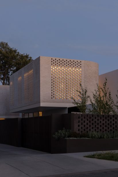 Light shining out from perforated brickwork facade