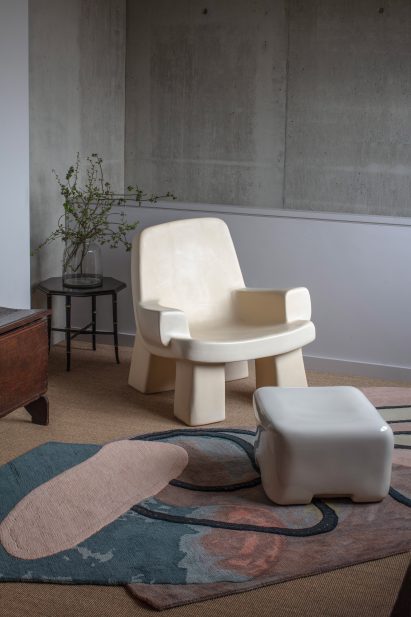Photograph of a chair and stool in corner of living room