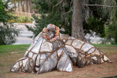 A sculpture clad in metallic materials and wrapped in ropes