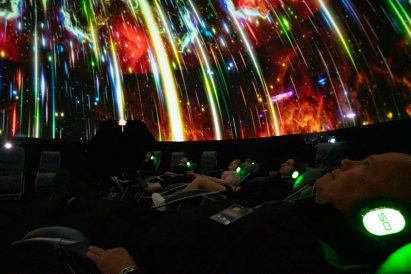 People looking up at a colorful projection