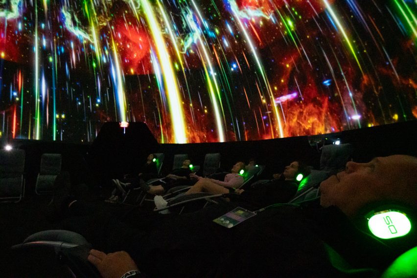 People looking up at a colorful projection