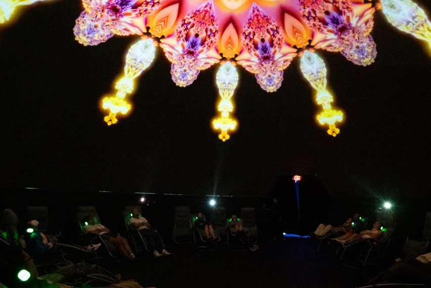 People looking up at a colorful projection