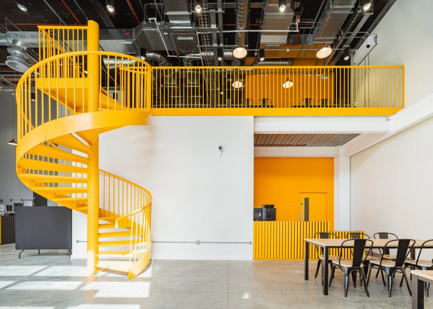 Industrial cafe with a yellow spiral staircase